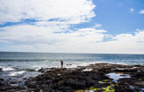 Keith Britton photographing Dunstanburgh Castle on the shore of the North Sea, England